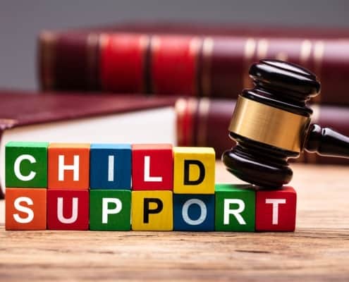 Blocks sits in front of a gavel, spelling out "Child Support."