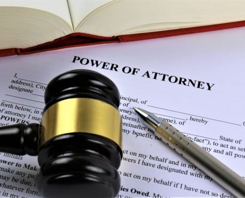 A gavel lays atop a Power of Attorney document created by a power of attorney lawyer.