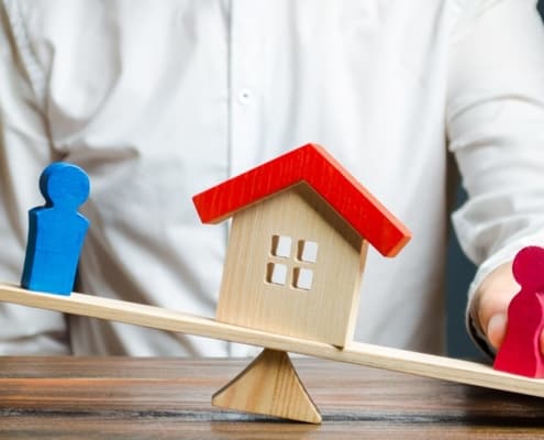 A divorce attorney in San Jose places two spousal figurines on opposing sides of a wooden house.