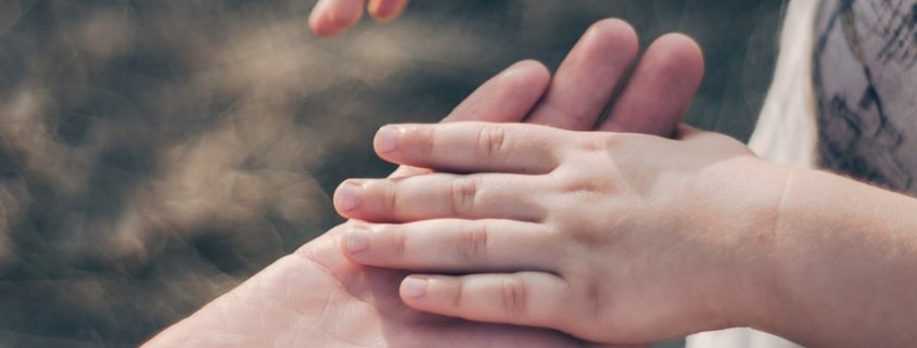 A child holds his parents hand as custody issues arise during Coronavirus