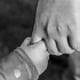 A black and white photo of a parent holding a child's hand after getting child custody