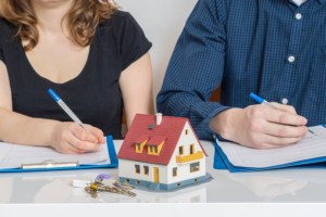 After asking how is property divided in a divorce, a couple signs corresponding documents that will divide their property.
