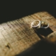 A married couple's rings sit on a wooden table as they contemplate a postnuptial agreement