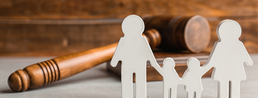 Wooden family figures and gavel on table. Child custody