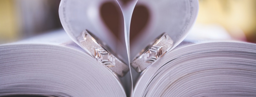Wedding rings rest between prenuptial agreement documents