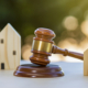 Gavel between two homes conveying concept of estate planning, starting your estate plan