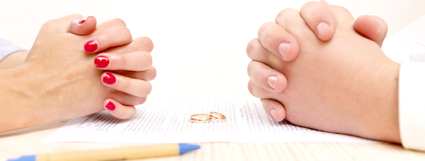 Couple facing each other with hands folded, signing prenup