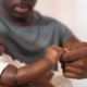 Father holding newborn son's hand, contesting paternity