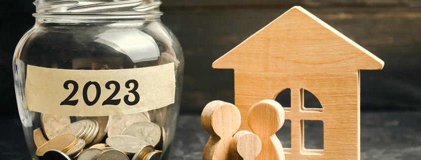 Glass jar with coins labeled 2023 and wood cutouts of family and wooden house. Estate Planning Tips to Keep Money in the Family