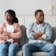 Disappointed couple with arms crossed on chest having relationships crisis, sitting on couch and looking aside, do not talking to each other after fight. Legal Separation agreement.
