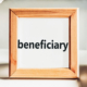 Beneficiary word in a wooden frame on the office table. Business concept. You may have recently discovered that you are a beneficiary of a trust.