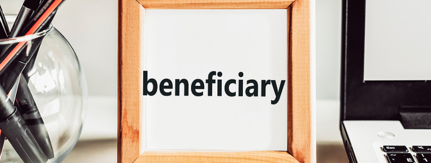 Beneficiary word in a wooden frame on the office table. Business concept. You may have recently discovered that you are a beneficiary of a trust.