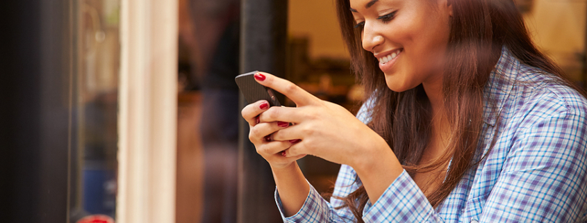 Woman Viewed Through Window Of Caf??? Using Mobile Phone. social media
