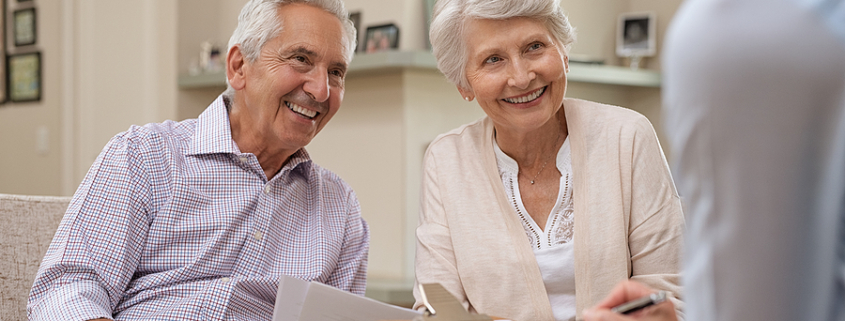 Senior couple meeting real estate agent at home. Old husband and wife with financial advisor for investment opportunities. Happy elderly man and woman listening to various investment plans. parents