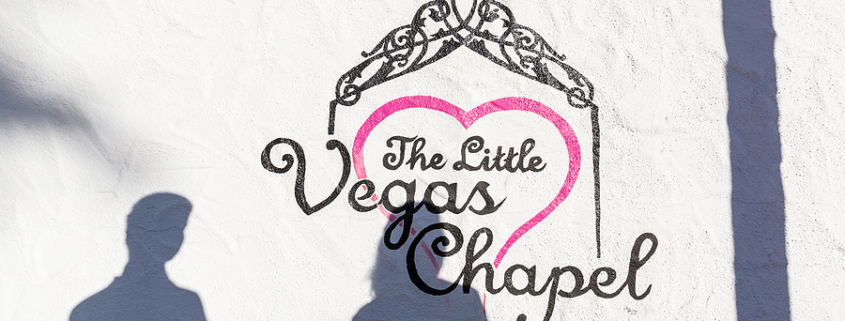 A young couple stands in front of a wedding chapel in Las Vegas on. Fast wedding chapel are popular by tourists and domestic people of Las Vegas.