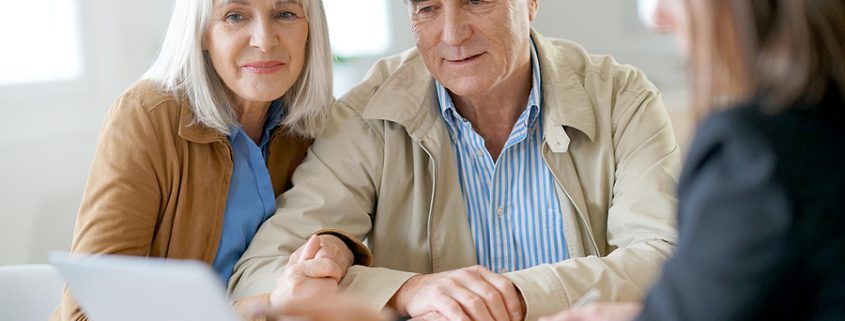 Senior couple meeting financial adviser to review estate plan and living trust.