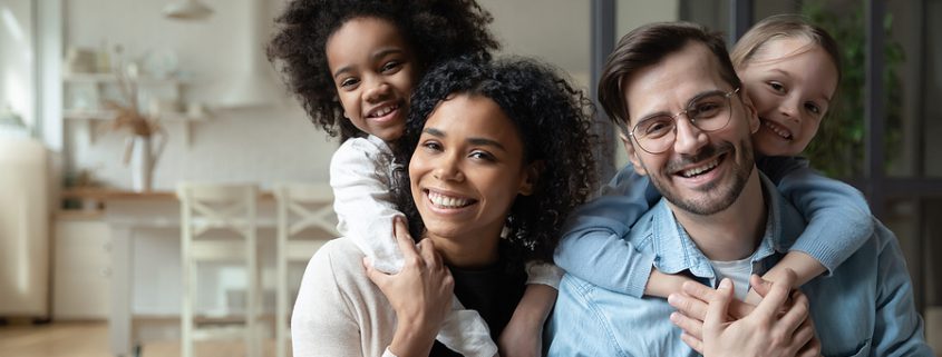 Happy multiracial couple enjoying time with their children, representing the love and unity found in blended families.