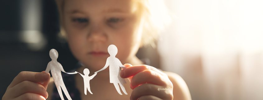 Little girl holding paper family cutout, symbolizing divorce and custody issues when mediation fails.