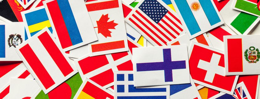 Top view of a heap of national flags from various countries, symbolizing global family dynamics and cross-border connections.”