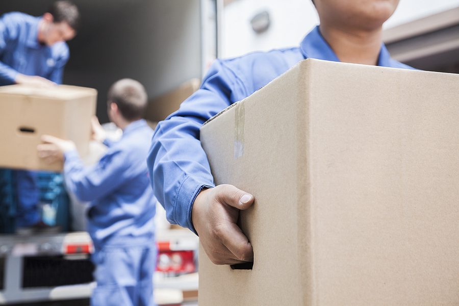 Movers unloading a van filled with boxes during a long-distance move across State lines