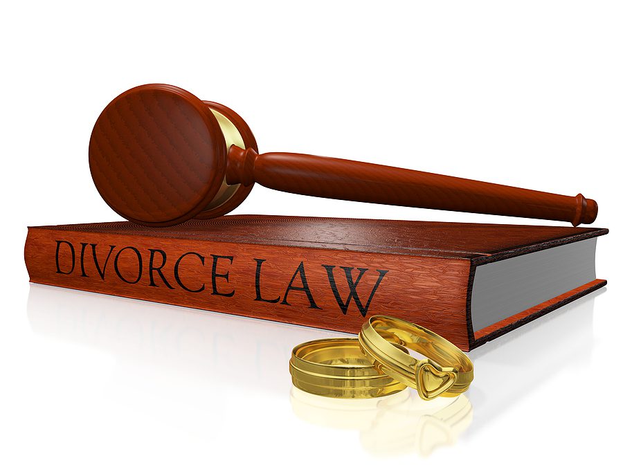 A law book labeled “Divorce Law” sits beside a judge’s gavel and two wedding bands, symbolizing the legal and emotional aspects of a no-fault divorce.