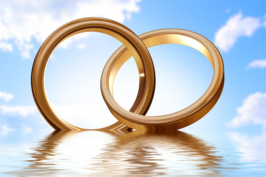 Two golden wedding rings placed together on a light surface, symbolizing marriage and prenuptial agreements.