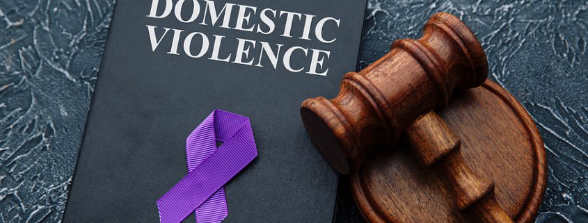 Melanie’s Law concept with judge gavel and domestic violence legal document on grey table symbolizing protection and legal reform