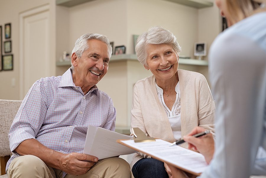 Senior couple meeting a financial advisor at home, discussing plans to choose the right executor for their estate