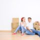 Young couple resting on the floor after moving into a new home, symbolizing cohabitation and starting life together.