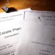 Estate planning documents and trusts arranged on a desk with legal forms for wills, healthcare, and asset protection.