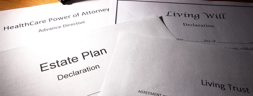 Estate planning documents and trusts arranged on a desk with legal forms for wills, healthcare, and asset protection.