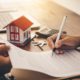 Estate Planning Pitfalls concept with couple signing real estate and estate planning documents with advisor.