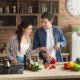 Happy couple cooking together at home, representing modern cohabitation and shared living.