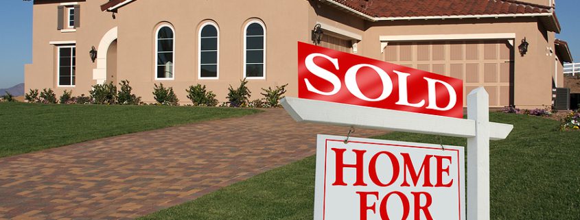 Real Estate sold sign displayed in front of a newly built home, symbolizing a successful property sale and homeownership.