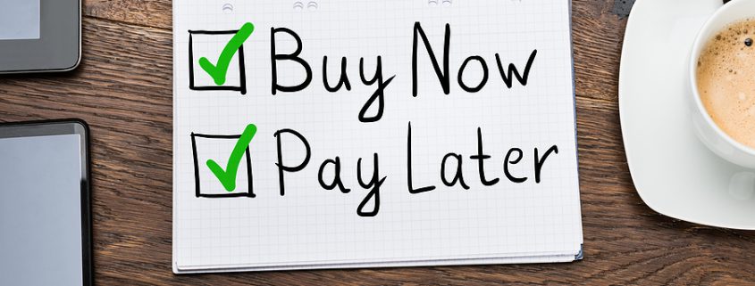 Buy Now Pay Later notepad on a desk with pen and coffee, illustrating marital debt considerations