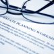 Reading glasses resting on an estate planning worksheet for child-free individuals planning ahead