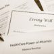Estate plan documents including a living will and healthcare power of attorney on a desk.