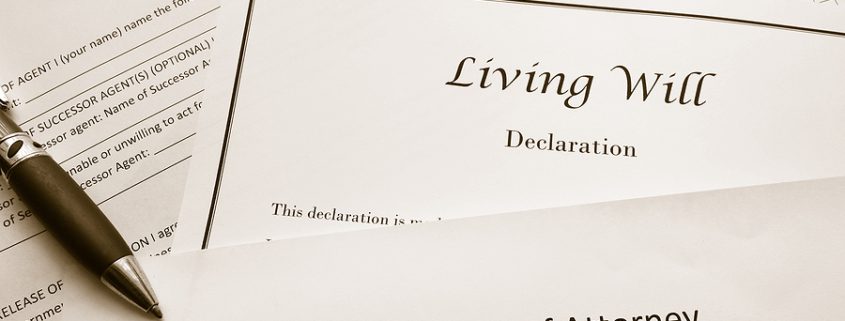Estate plan documents including a living will and healthcare power of attorney on a desk.