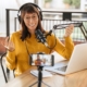 Digital assets content creator laughing on a podcast while recording with smartphone and headphones