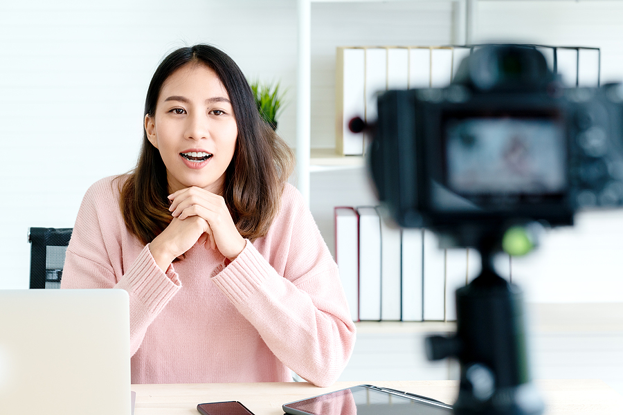 Digital assets of a vlogger, young woman talking to the camera while filming a video for her channel